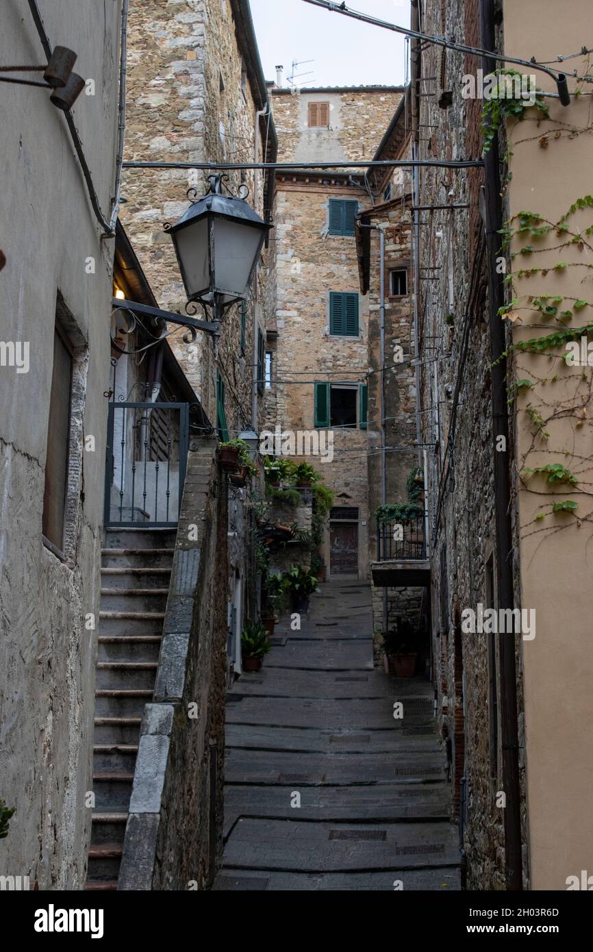 Eine dünne, nasse italienische Kopfsteinpflasterstraße in einer Stadt auf einem Hügel in Italien Stockfoto