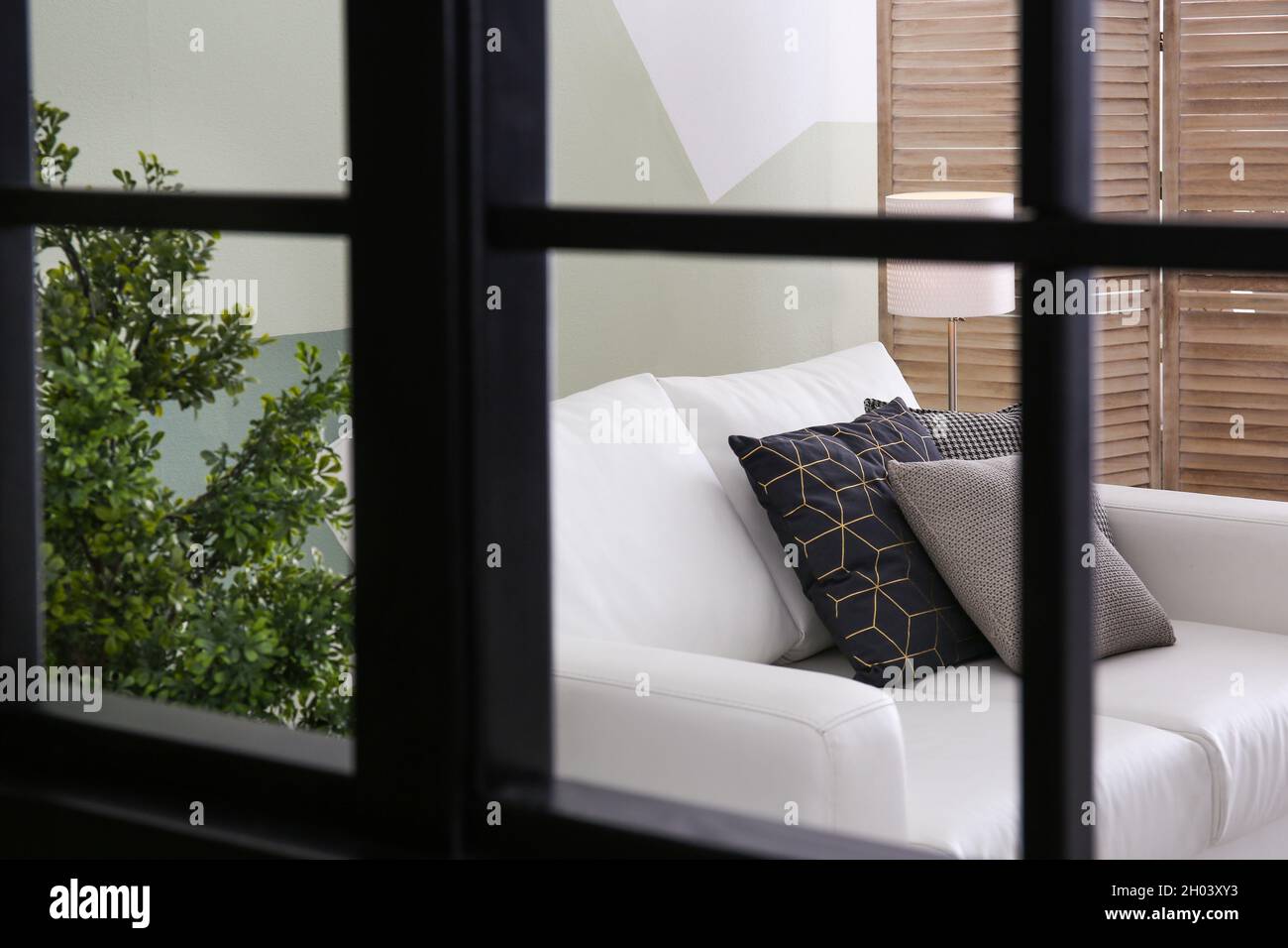 Wohnzimmer mit komfortablem Sofa, Blick durch das Fenster Stockfotografie -  Alamy
