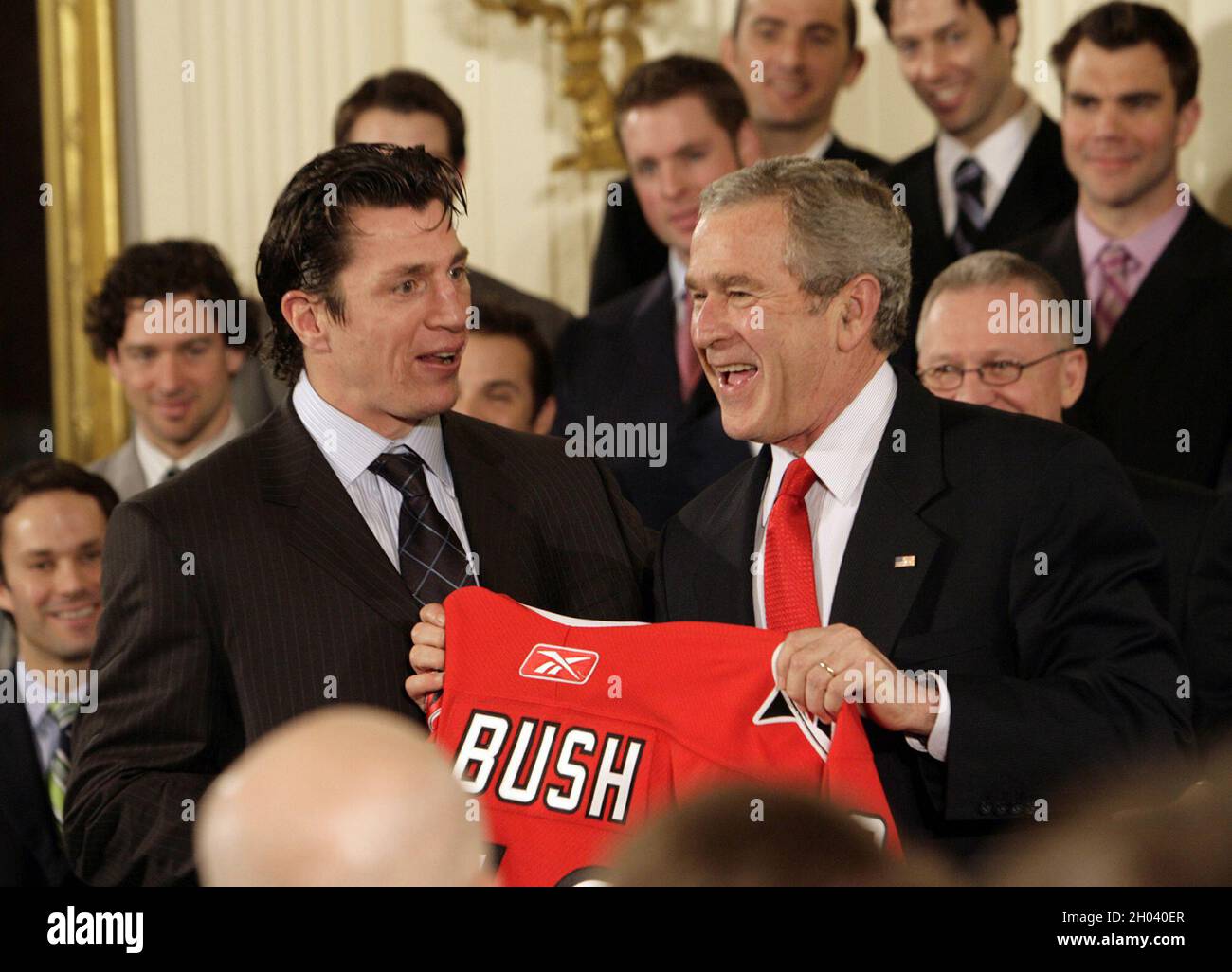 Washington, USA. Februar 2007. In diesem Aktenfoto überreicht der Kapitän der Carolina Hurricanes, Rod Brind'Amour, links, Präsident George Bush während einer Zeremonie im East Room des Weißen Hauses in Washington, DC, am 2. Februar 2007 einen Hurricanes-Pullover mit dem Namen des Präsidenten. Der Präsident gratulierte dem Team zu seiner NHL Stanley Cup Meisterschaft im Juni 2006. (Foto: Chris Seward/Raleigh News & Observer/TNS/Sipa USA) Quelle: SIPA USA/Alamy Live News Stockfoto