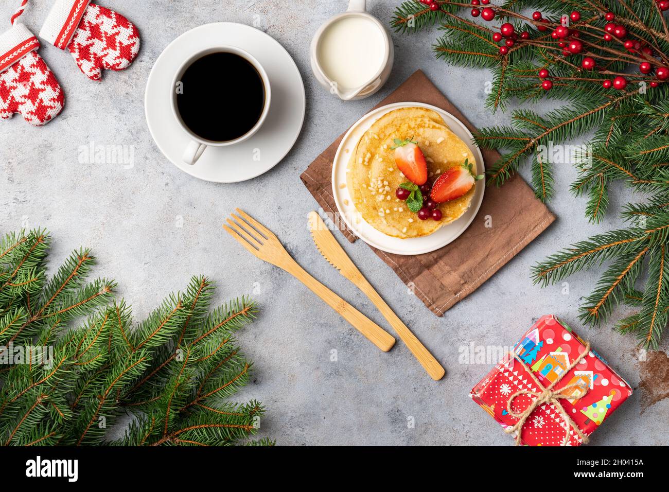 Weihnachtsfrühstück und Geschenke mit Weihnachtsbaumzweigen geschmückt. Draufsicht Stockfoto