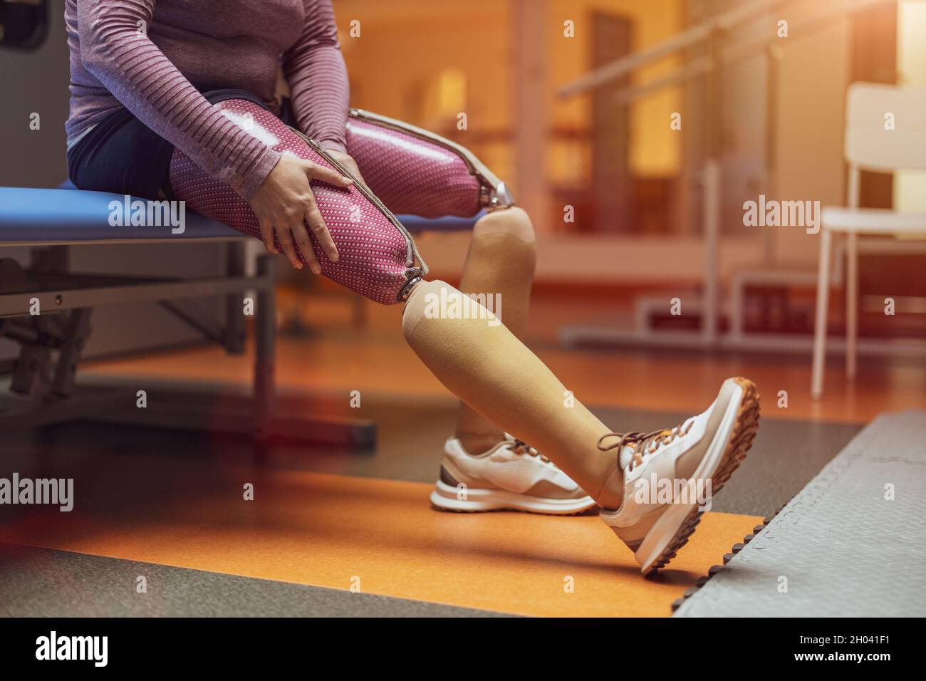 Junge Frau mit prothetischen Beinen, die im Physiotherapie-Zentrum trainiert Stockfoto