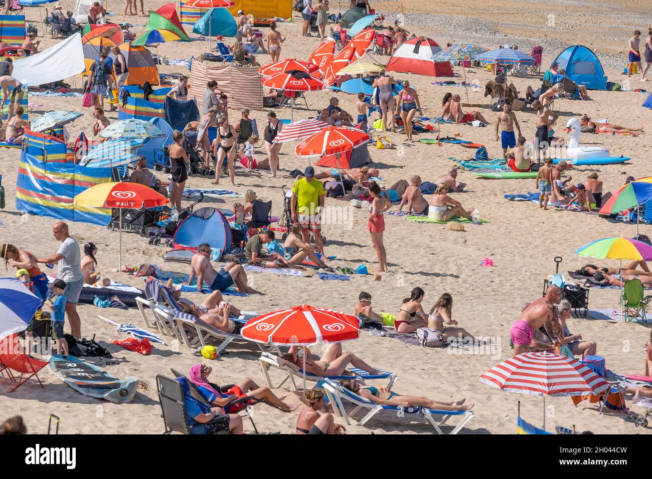 Fistral Beach in Newquay in Cornwall. Urlaubsreisende drängen sich zum Fistral Beach, um die intensive Sommersonne zu genießen. Stockfoto