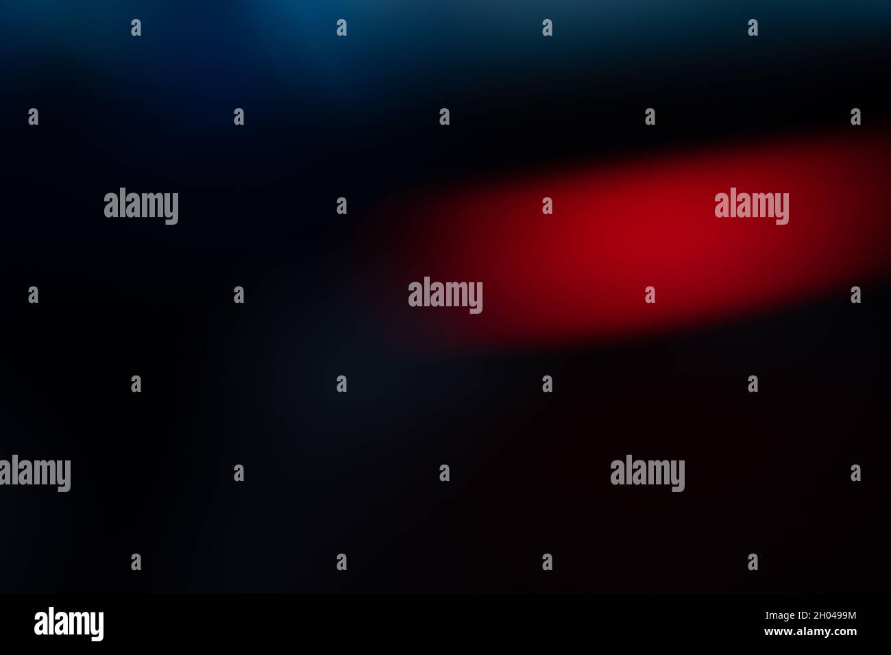 Farbverlauf in Neonfarben. Beweglicher abstrakter unscharfer Hintergrund. Die Farben variieren je nach Position und erzeugen weiche Farbübergänge. Rot, schwarz und blau. Stockfoto
