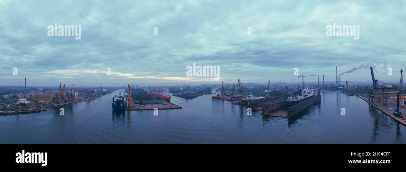 Luftpanorama der Sonnenaufgang mit bewölktem Himmel unter Remontova Werft mit Schiffen in Trockendocks. Danzig, Polen, Stockfoto