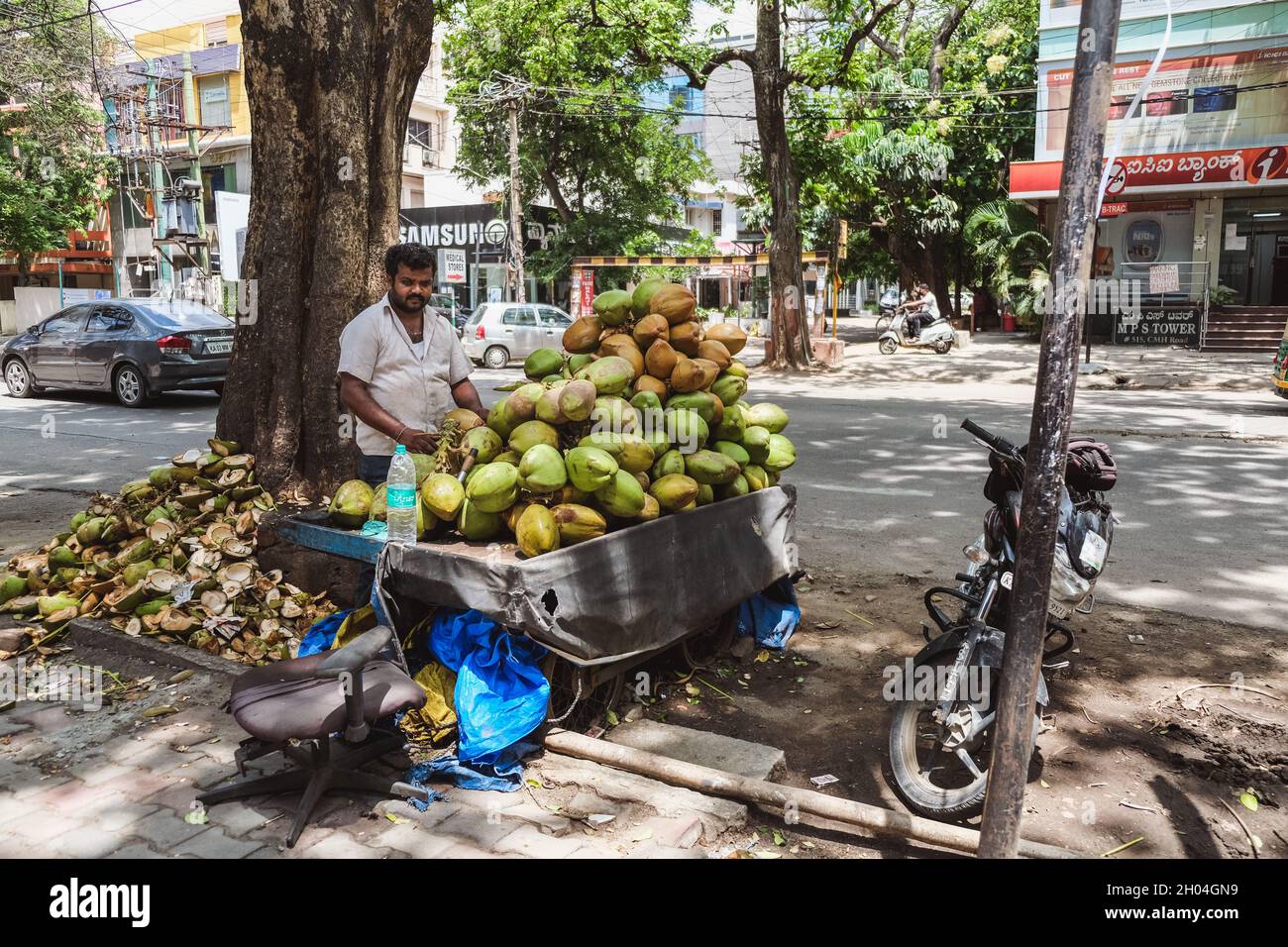 Bangalore, Indien - 04. Mai 2020: Ein Verkäufer kokonut mit scharfem Messer auf der Straße in Bangalore City tagsüber Stockfoto