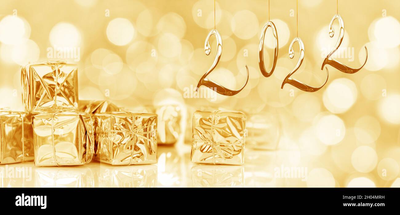 2022, Jahreskarte. Kleine Weihnachtsgeschenke in glänzendem goldenem Papier, panoramischer Webbanner Stockfoto