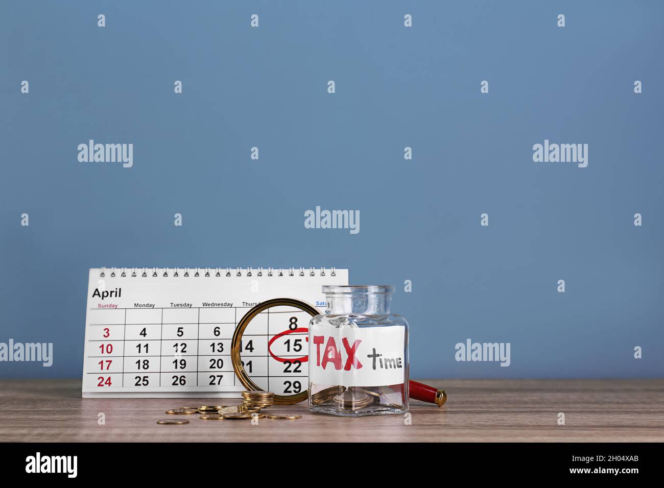 Kalender, Glas mit Etikett 'TAX TIME' und Münzen auf dem Tisch  Stockfotografie - Alamy