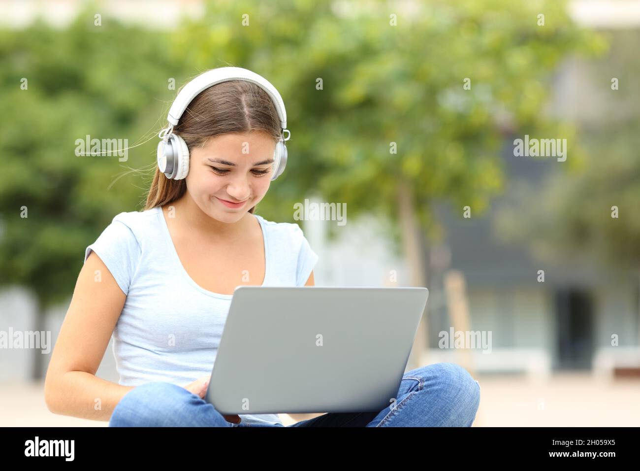 Fröhliche Studenten elearning mit Laptop und Kopfhörer auf einem Campus Stockfoto