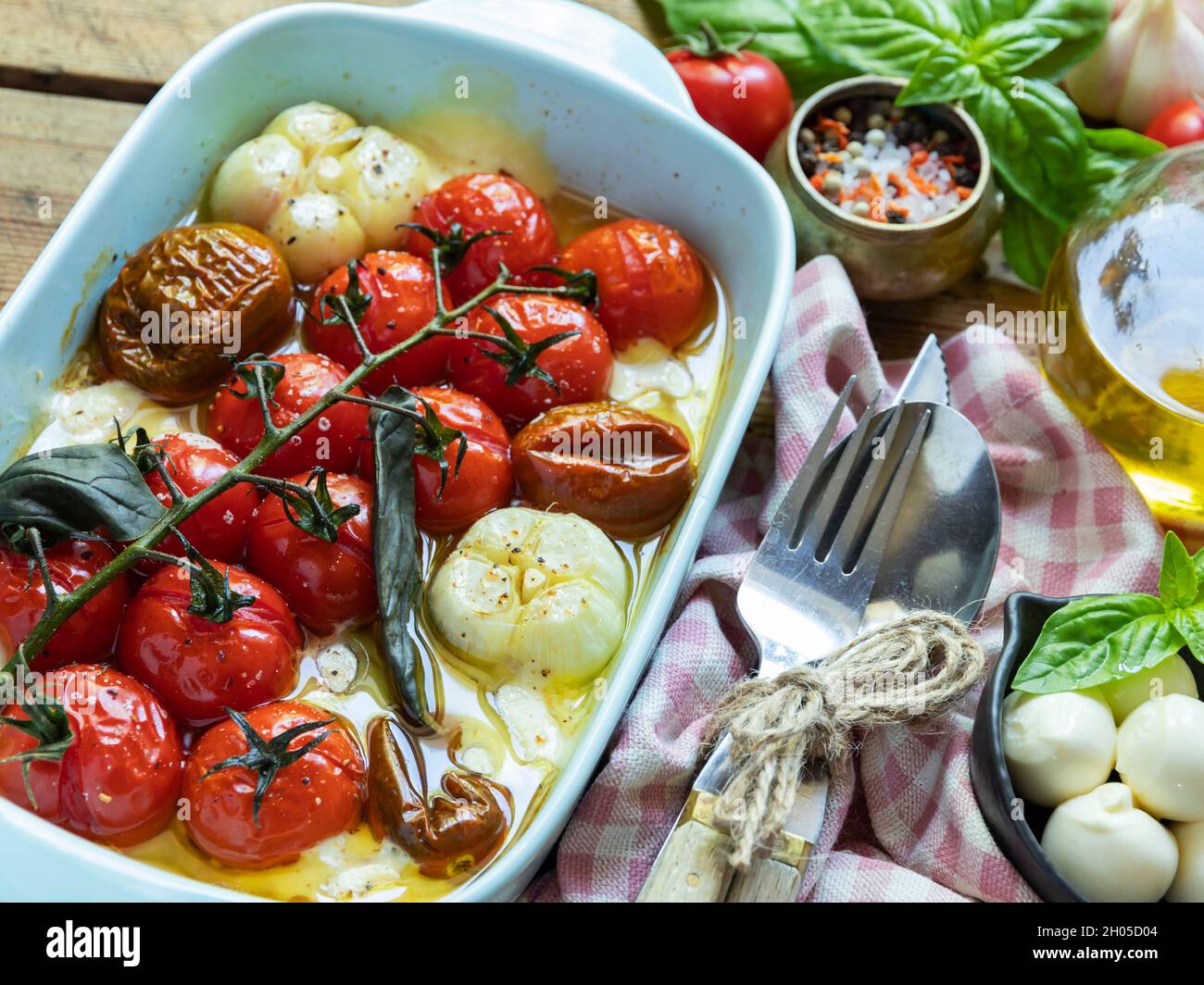 Gebackene Gemüsestomate, Basilikum, Mozzarella-Käse, Knoblauch im Ofen in keramischen Gerichten. Kochen, gekochtes Gericht aus der Nähe Stockfoto