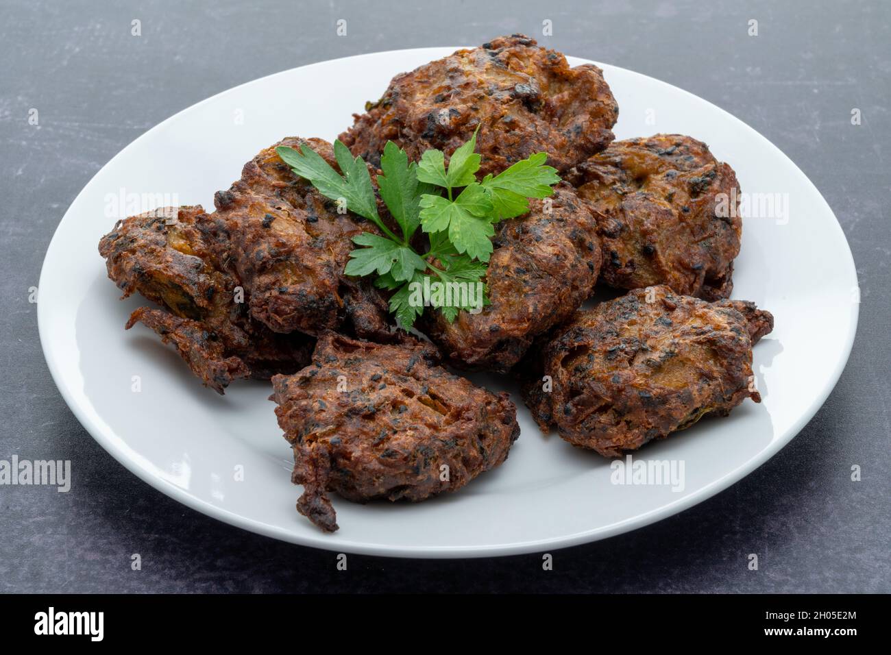 Indische Gerichte zum Mitnehmen mit würzigen Zwiebelbhajis Stockfoto