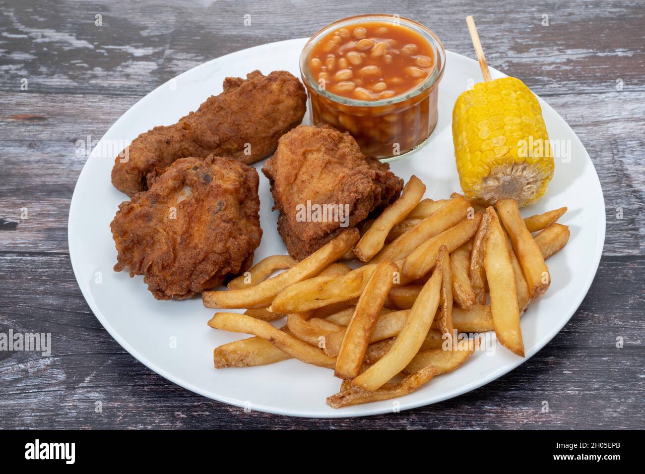 Gebratenes Huhn mit Pommes Frites, gebackene Bohnen und Süßmais Abendessen Stockfoto