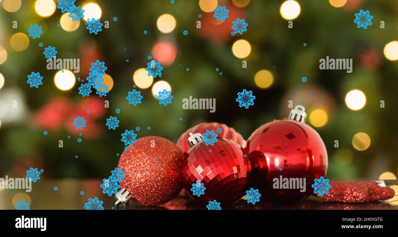 Bild des Schnees, der über weihnachtskugeln fällt Stockfoto