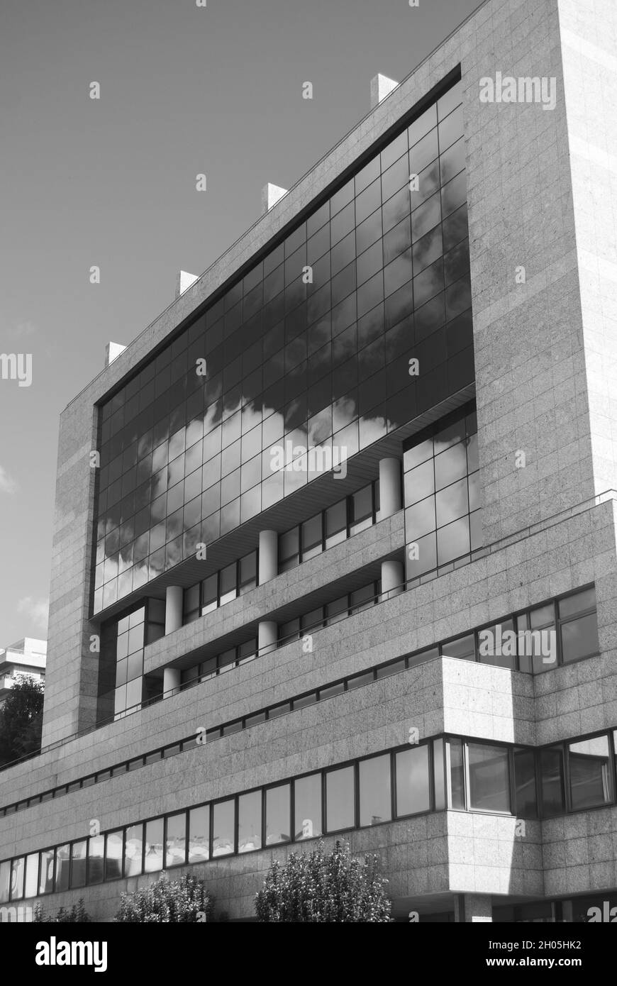 Abstrakte Stadtarchitektur, Spiegelung des bewölkten Himmels in den Fenstern des Wolkenkratzers des Gebäudes, mit Glas bedeckt - Schwarz-Weiß, Monochrom Stockfoto