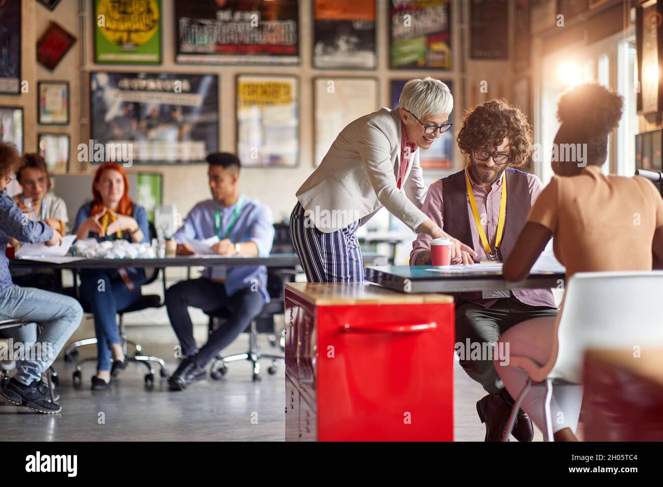 Menschen in zwei Gruppen, unterschiedlichem Alter, Rasse und Geschlecht, arbeiten im Freiraumbüro zusammen Stockfoto