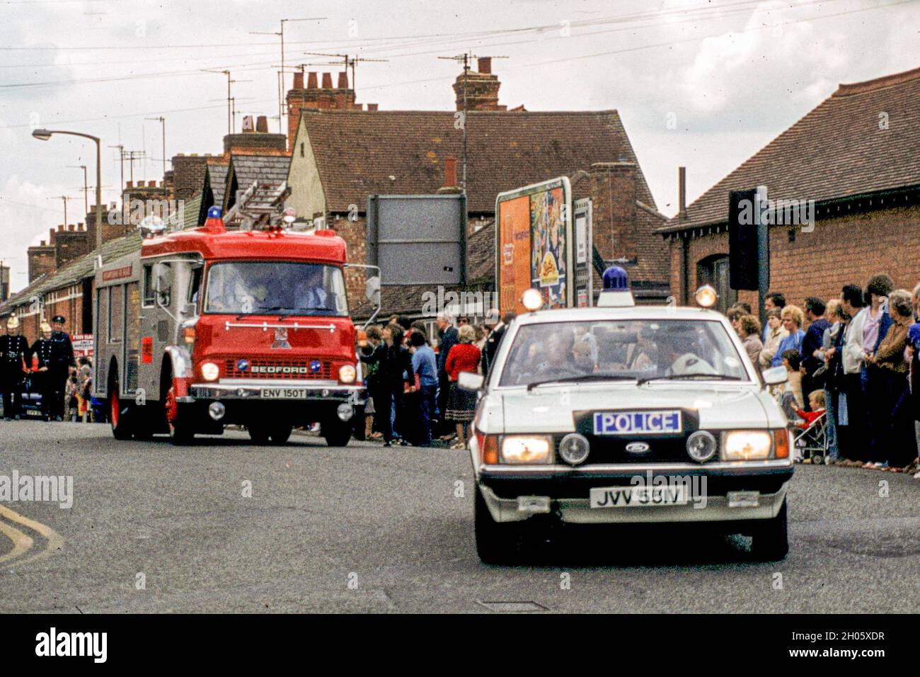 Ein Polizeiauto und ein Feuerwehrauto führten den Karneval in Rushden 1981 an Stockfoto