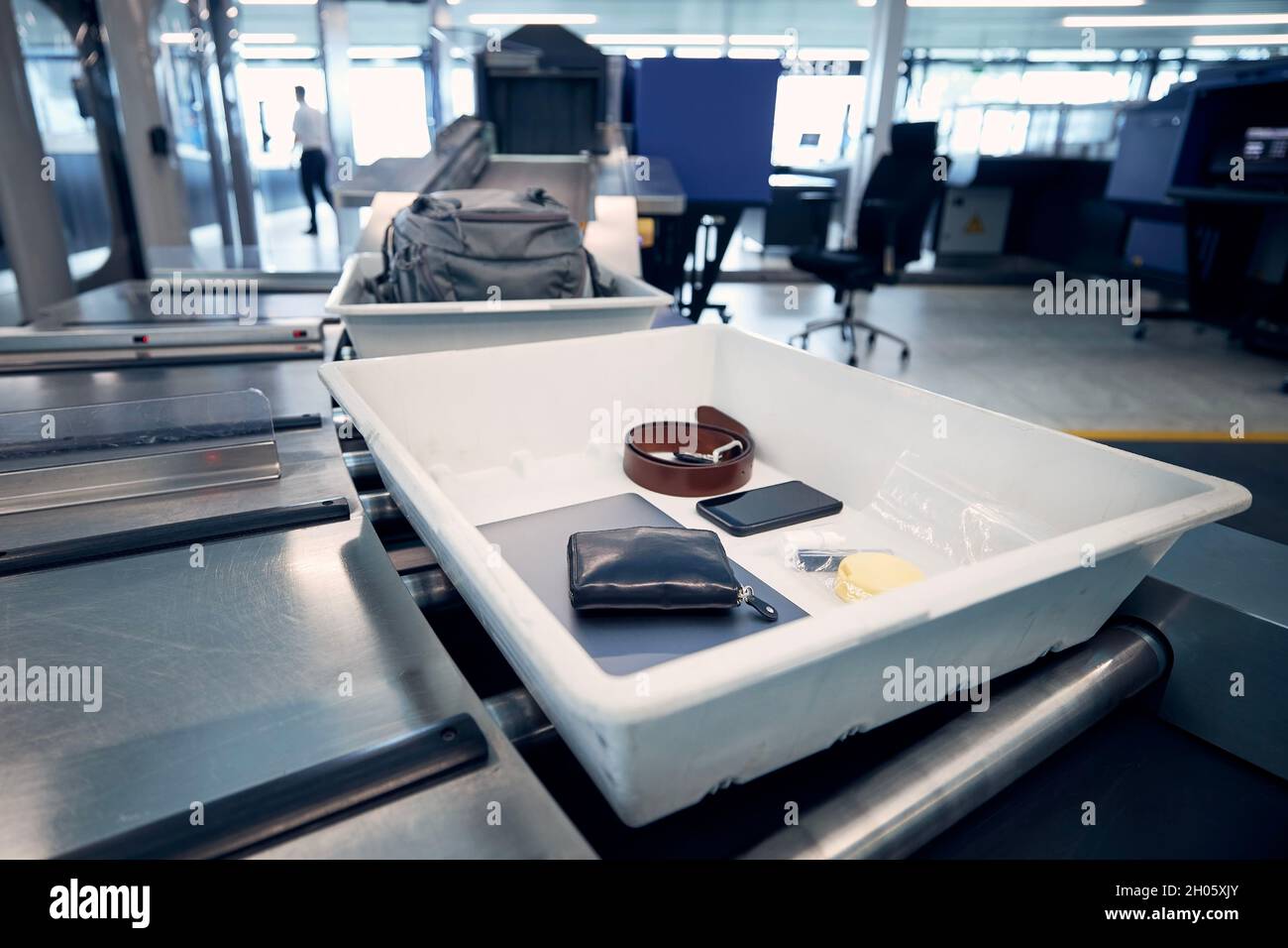 Persönliche Gegenstände, Flüssigkeiten und Laptop im Container bei der Sicherheitskontrolle des Flughafens vor dem Flug. Stockfoto
