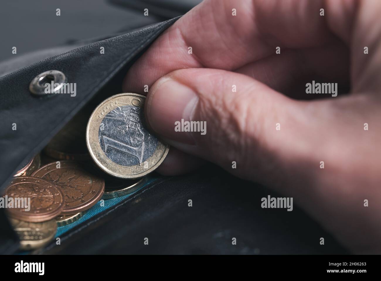 Nahaufnahme einer Person, die 1 Euro-Münze aus der Brieftasche nimmt, Taschengeld-Geschäftskonzept Stockfoto