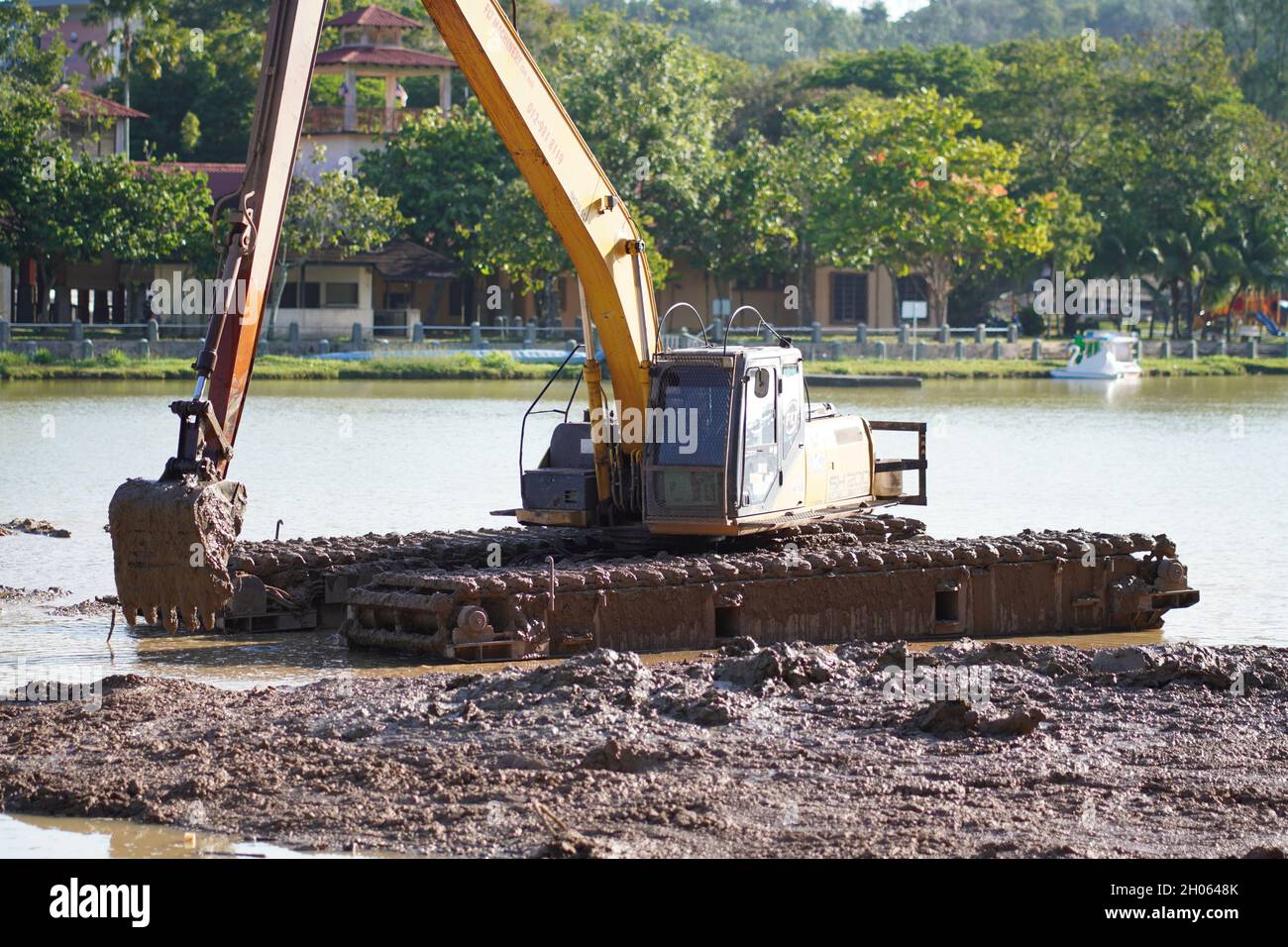 Land- und Wasserbagger mit amphibischen Baggern, die im Wasser arbeiten, um die Seenlandschaft zu verändern. Stockfoto