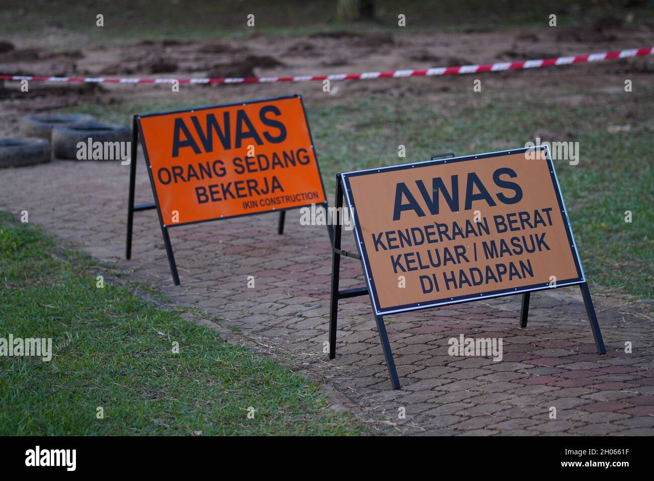 Achten Sie auf ein Schild in der Mitte des Joggingpfades, das die Öffentlichkeit vor den Bauarbeiten warnt. Auf dem Schild steht, dass schwere Fahrzeuge vor uns sind Stockfoto