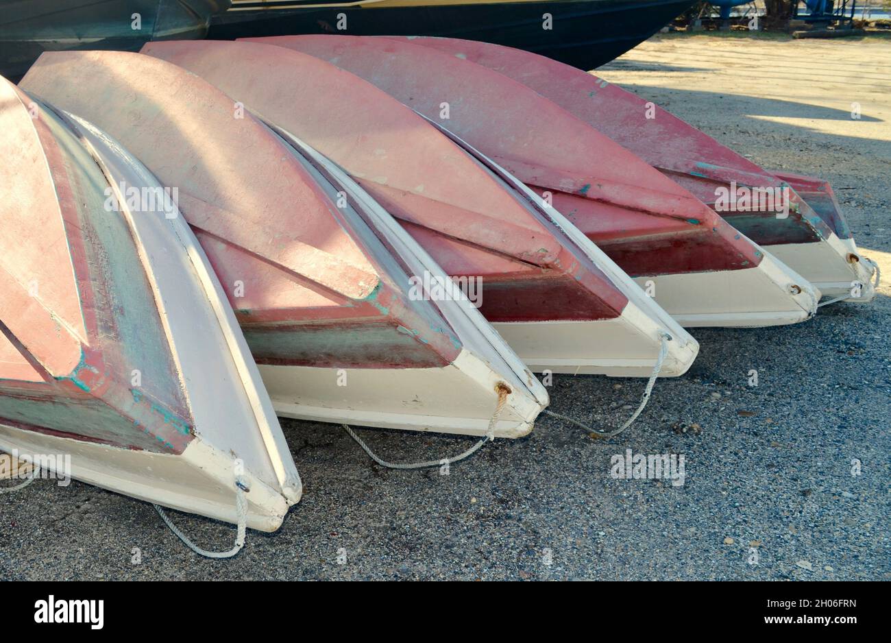 Ende der Bootssaison - Ruderboote mit rotem Grund werden geordnet aufeinander gestapelt. Nahaufnahme Stockfoto