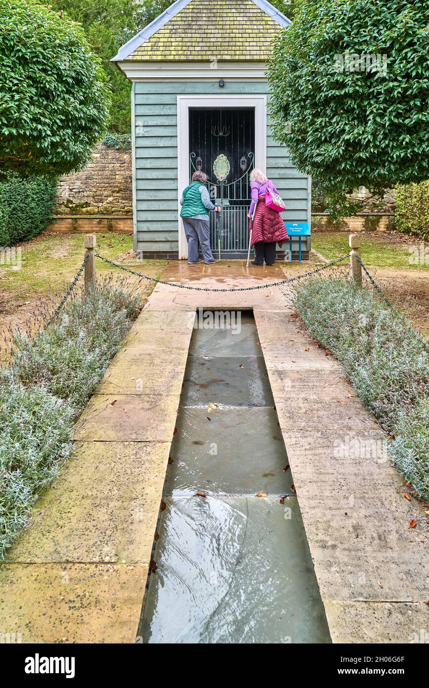 Zwei Besucherinnen blicken in das Water House im Garten der Überraschungen im Burghley House, Stamford, England. Stockfoto