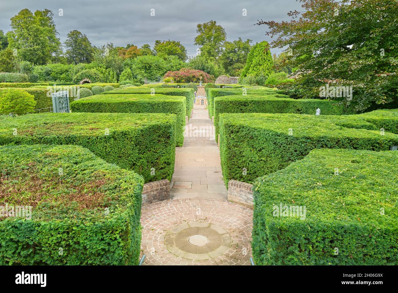 Von Hecken gesäumter Pfad zur Neptune's Grotto im Garten der Überraschungen im Burghley House, Stamford, England. Stockfoto