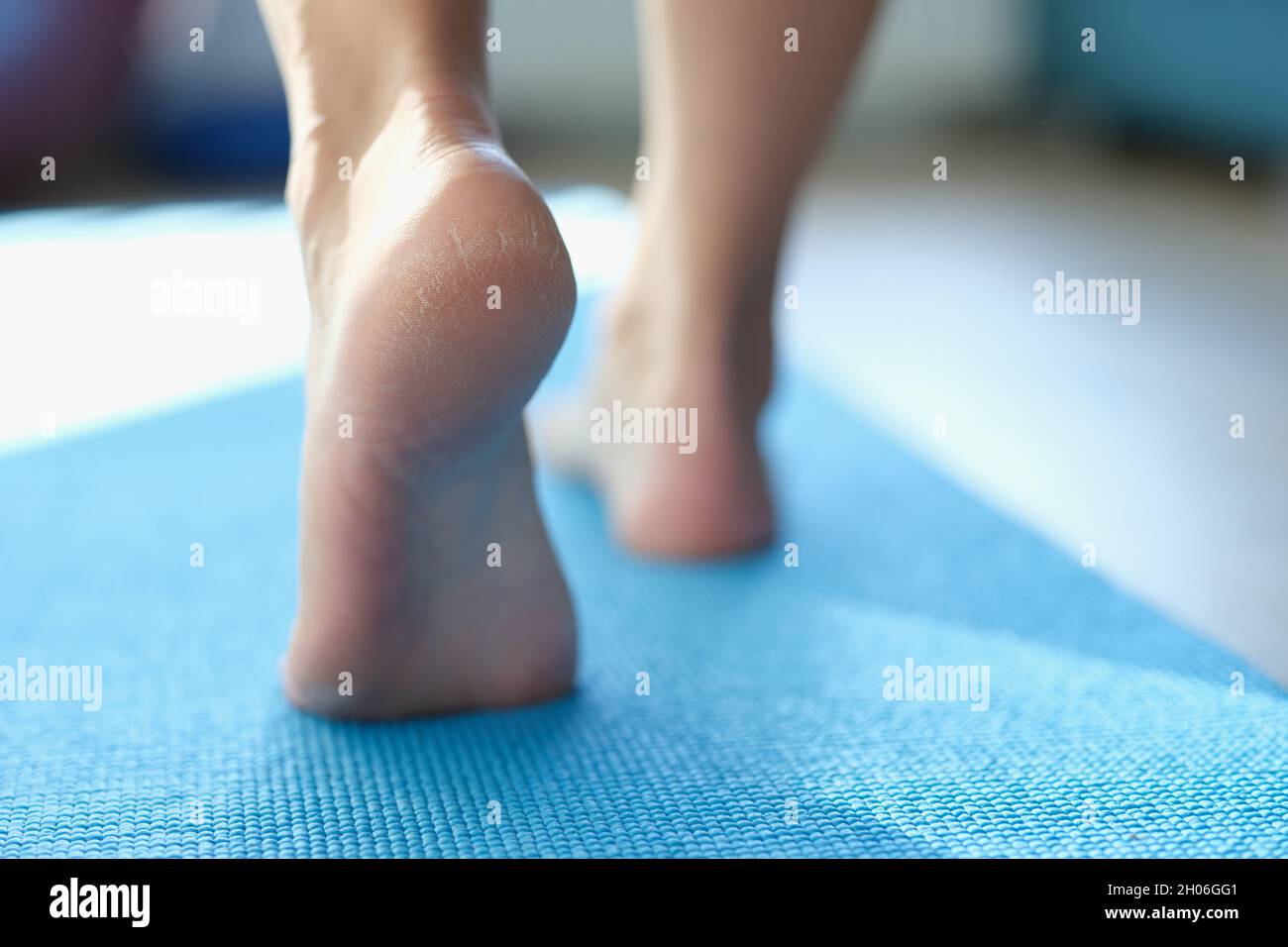 Frauen laufen auf einer Sportmatte mit trockener Haut auf den Fersen Stockfoto