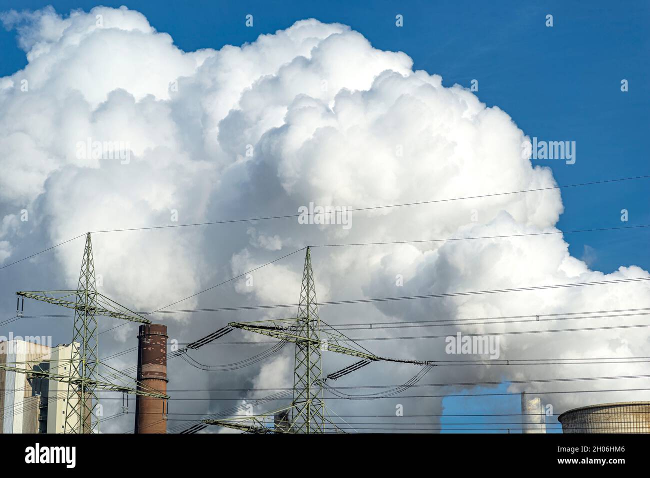 Weiße Wolken aus Wasserdampf, die aus dem Kühlturm einer Stromerzeugungsanlage hervorgehen. Stockfoto