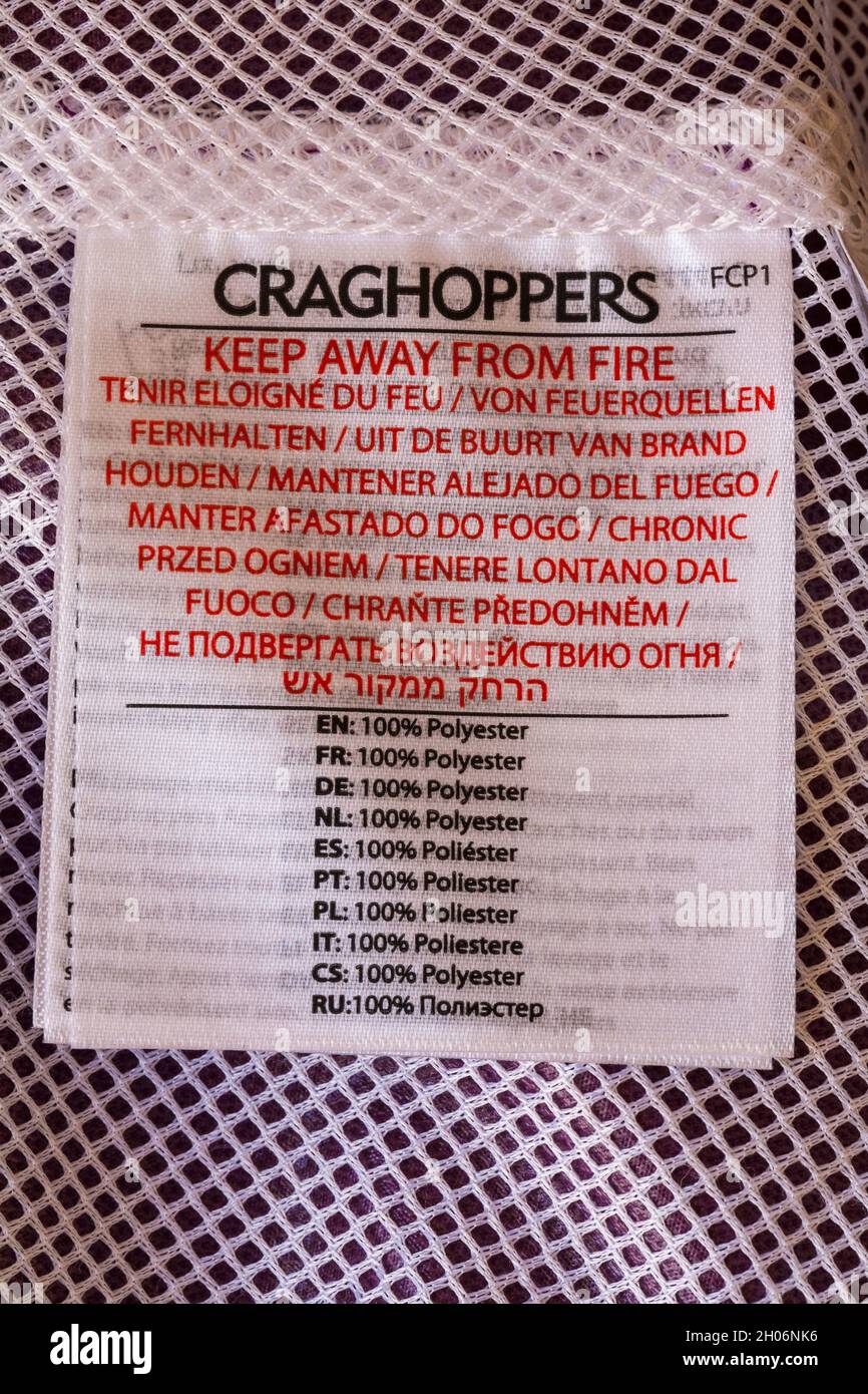 Vom Feuer fernhalten 100% Polyester in vielen verschiedenen Sprachen - Label auf Craghoppers Jacke Stockfoto
