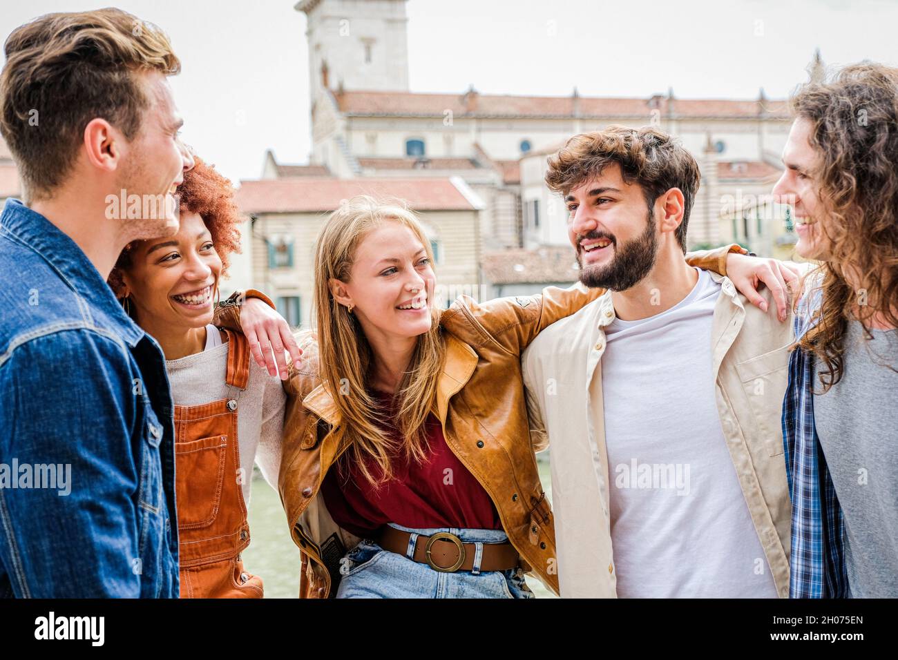 Gruppe von Freunden glücklich lachen zusammen - Gruppe von multirassischen Jungs Spaß auf der Straße der Stadt - Porträt von fünf Studenten aus verschiedenen Kulturen Stockfoto