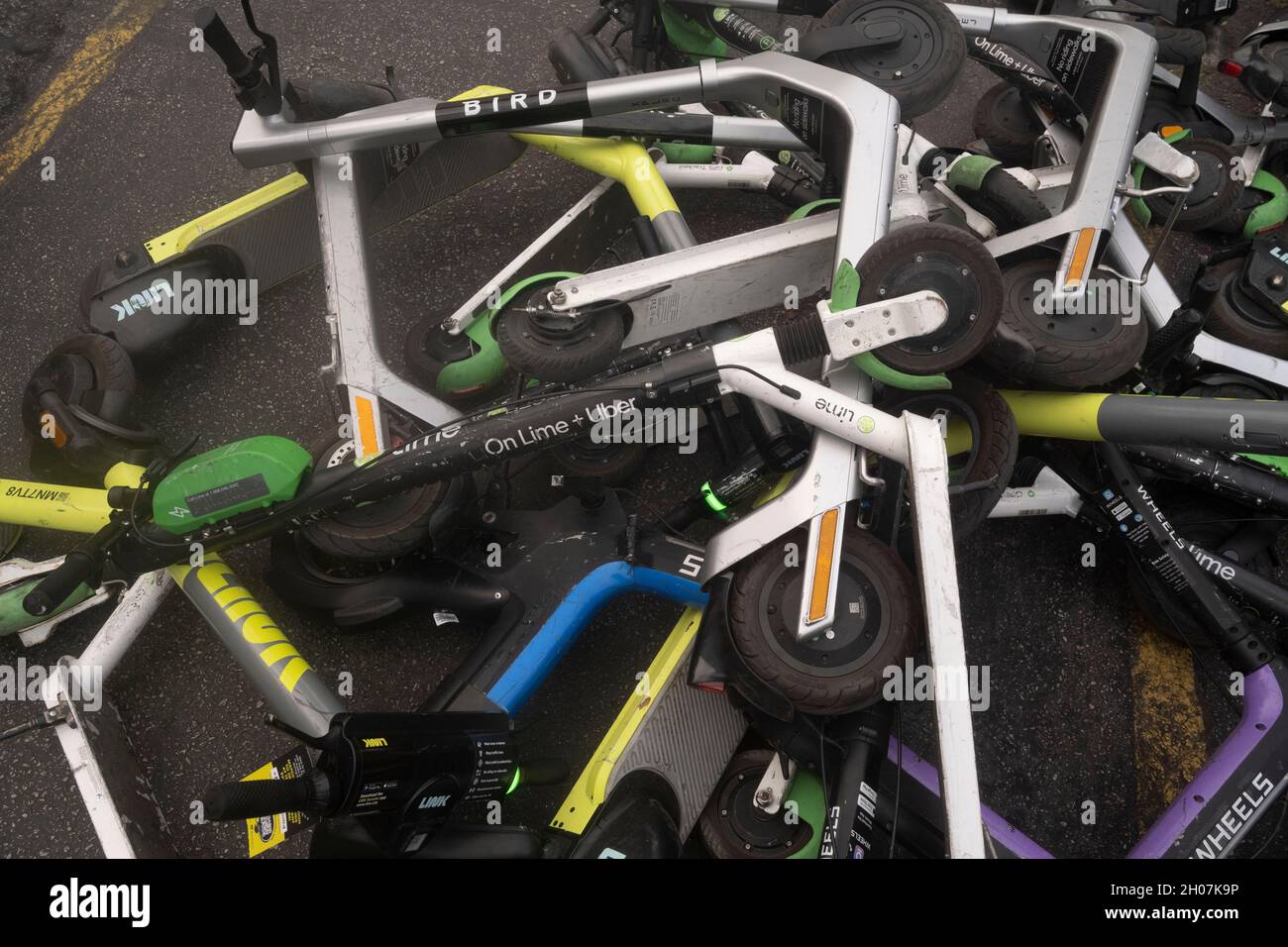 Austin, Texas, USA, 10. Oktober 2021: Elektroroller stellen nach einem geschäftigen Wochenende in den Unterhaltungsvierteln Red River und Rainey Street in der Innenstadt von Austin einen ungefährlichen Haufen und eine Gefahr für Fußgänger an der Ecke von East First Street und Red River dar. ©Bob Daemmrich Stockfoto
