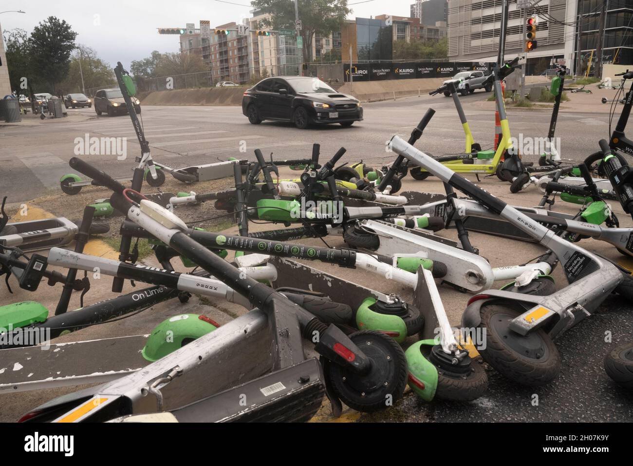 Austin, Texas, USA, 10. Oktober 2021: Elektroroller stellen nach einem geschäftigen Wochenende in den Unterhaltungsvierteln Red River und Rainey Street in der Innenstadt von Austin einen ungefährlichen Haufen und eine Gefahr für Fußgänger an der Ecke von East First Street und Red River dar. ©Bob Daemmrich Stockfoto