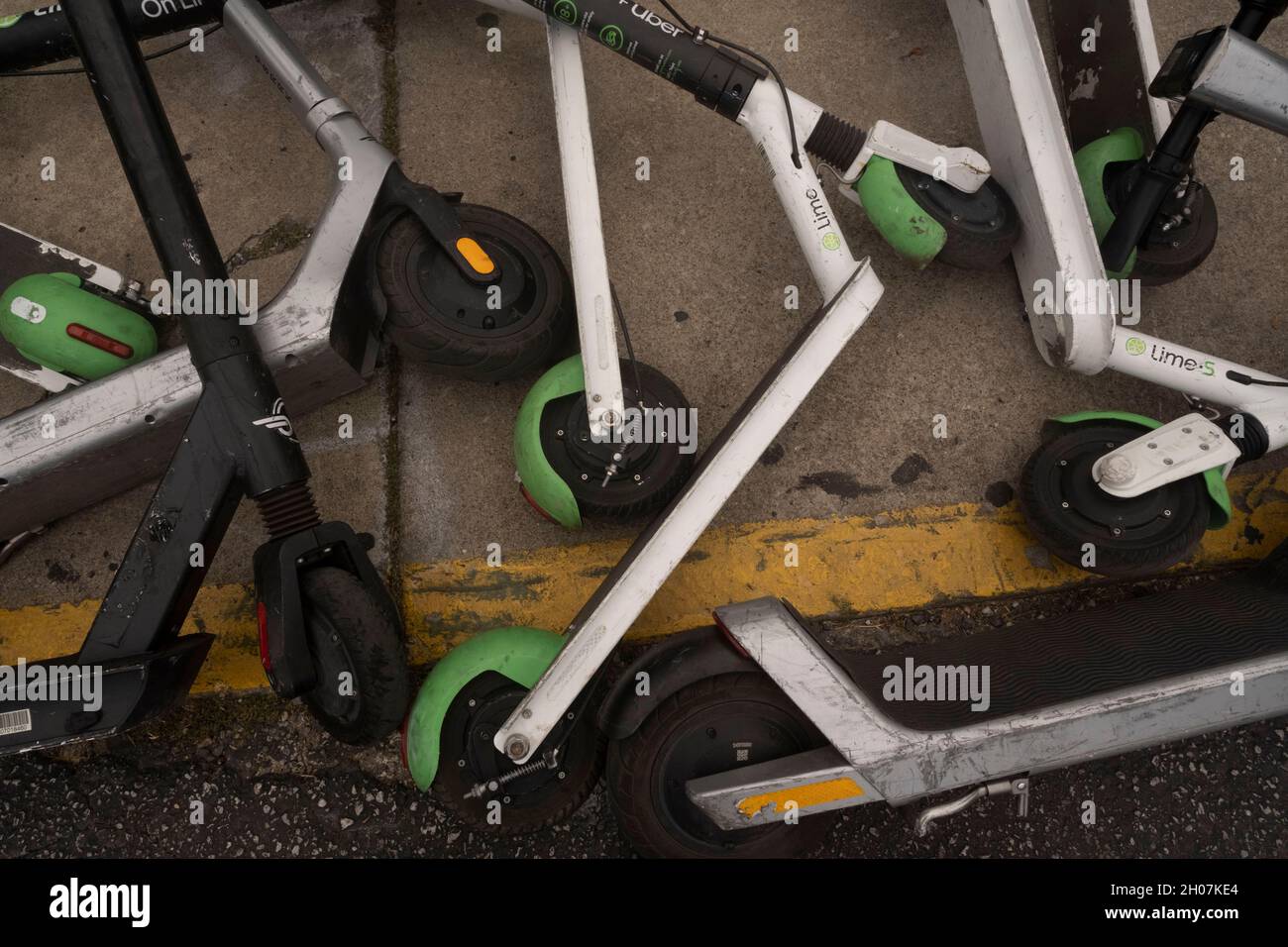 Austin, Texas, USA, 10. Oktober 2021: Elektroroller stellen nach einem geschäftigen Wochenende in den Unterhaltungsvierteln Red River und Rainey Street in der Innenstadt von Austin einen ungefährlichen Haufen und eine Gefahr für Fußgänger an der Ecke von East First Street und Red River dar. ©Bob Daemmrich Stockfoto