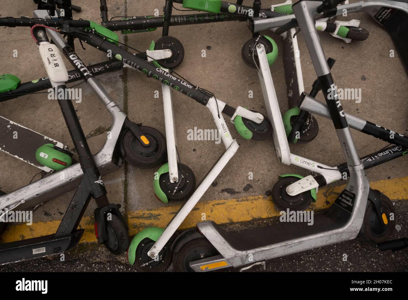 Austin, Texas, USA, 10. Oktober 2021: Elektroroller stellen nach einem geschäftigen Wochenende in den Unterhaltungsvierteln Red River und Rainey Street in der Innenstadt von Austin einen ungefährlichen Haufen und eine Gefahr für Fußgänger an der Ecke von East First Street und Red River dar. ©Bob Daemmrich Stockfoto