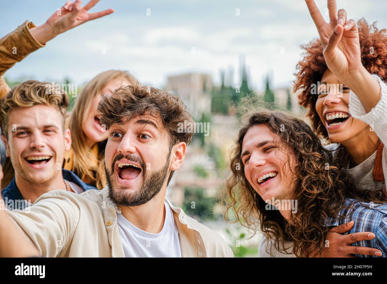 Freunde Studenten entspannen sich draußen, machen Gruppen Selfies und lächeln auf dem Smartphone, auf der Straße Stockfoto