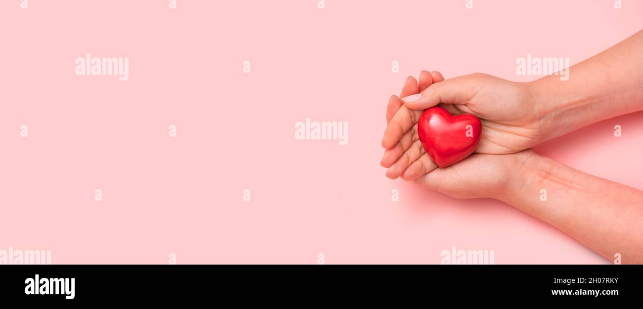 Gesundheitskonzept mit Herz in den Händen. Breites Bild mit Kopierbereich Stockfoto