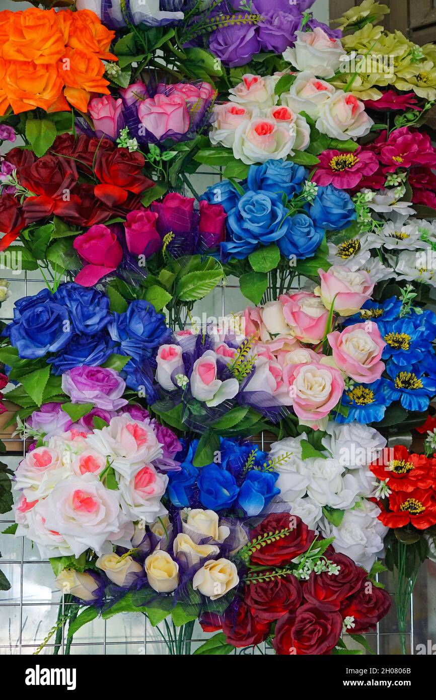 Bunte Plastikrosen gefälschten Blumen an der Wand Dekor Stockfotografie