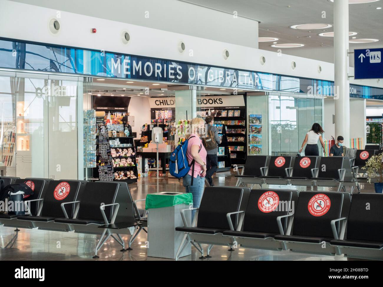 Teil der Passagier-Lounge des Flughafens Gibraltar mit dem Souvenir-Shop Memories of Gibraltar. Einige Passagiere mit Masken befinden sich in der Gegend. Stockfoto