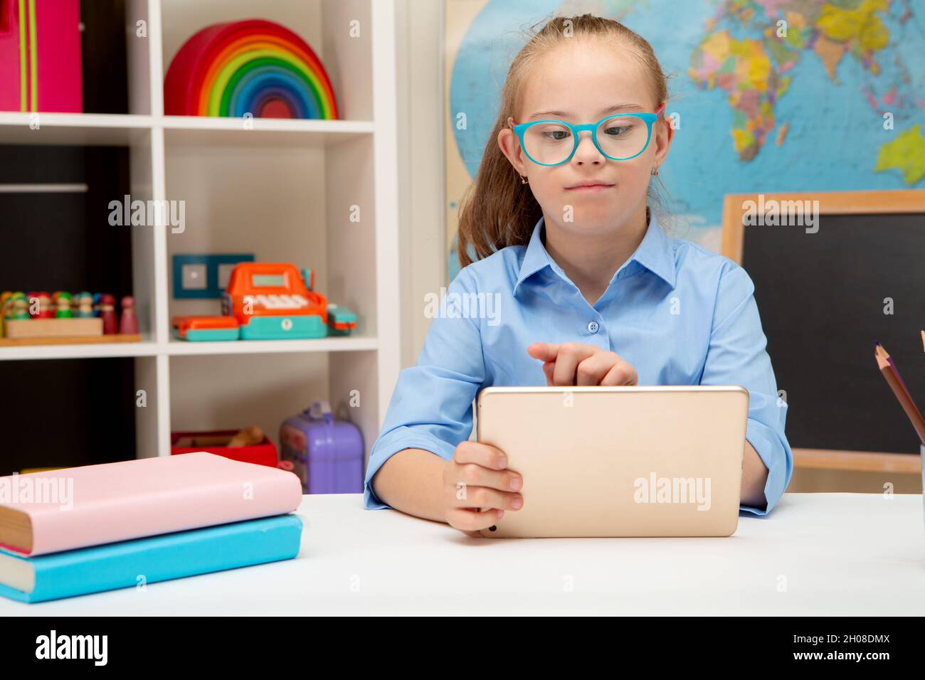 Ein Mädchen mit Down-Syndrom studiert online auf einem iPad zu Hause Stockfoto
