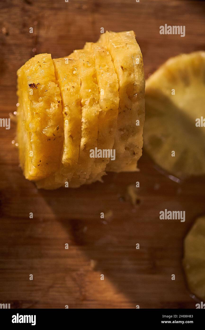 Hände schälen frisch geschnittene Ananasscheiben, gesundes Essen. Stockfoto