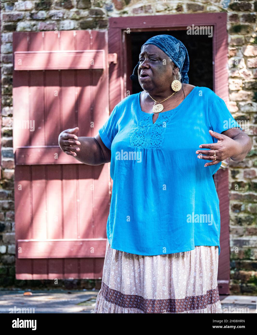 Ein Foto eines Gullah-Geschichtenerzählers, der in der „Slave Street“ auftrat, einer Reihe von erhaltenen Sklavenunterkünften aus Backstein in der Boone Plantation. Stockfoto