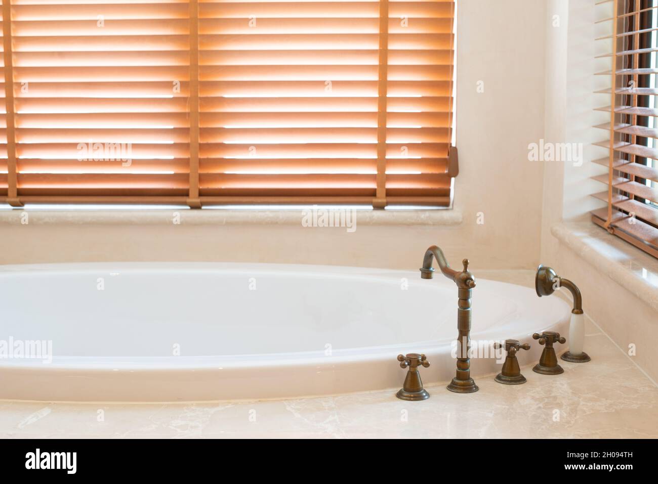 Kupferhahn mit heißem und kaltem Wasser in der Badewanne. Stockfoto
