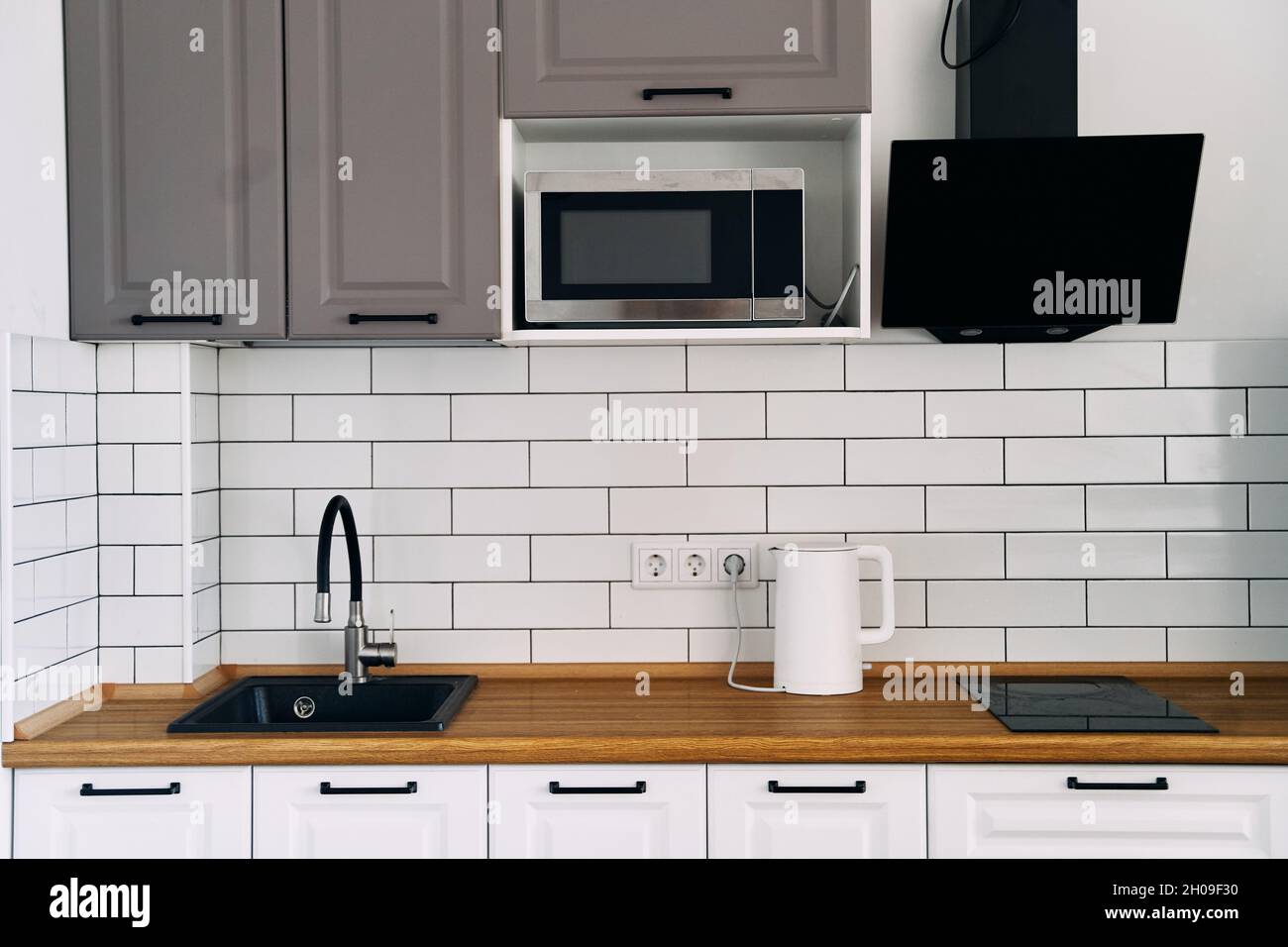 Weiße Schränke mit Holztheke der modernen Küche Stockfoto