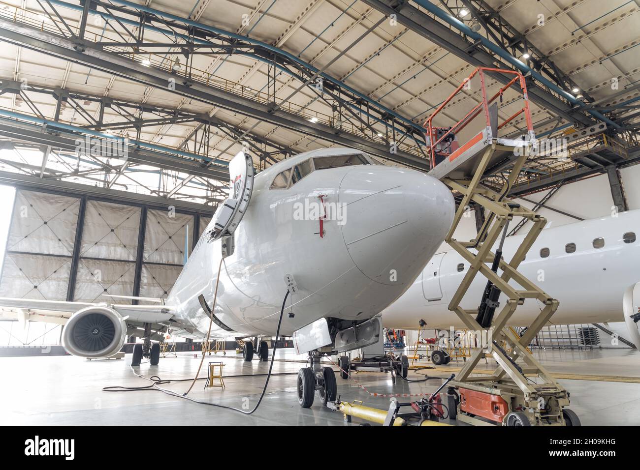 Großes weißes Flugzeug im Hangar während der Reparatur Stockfoto