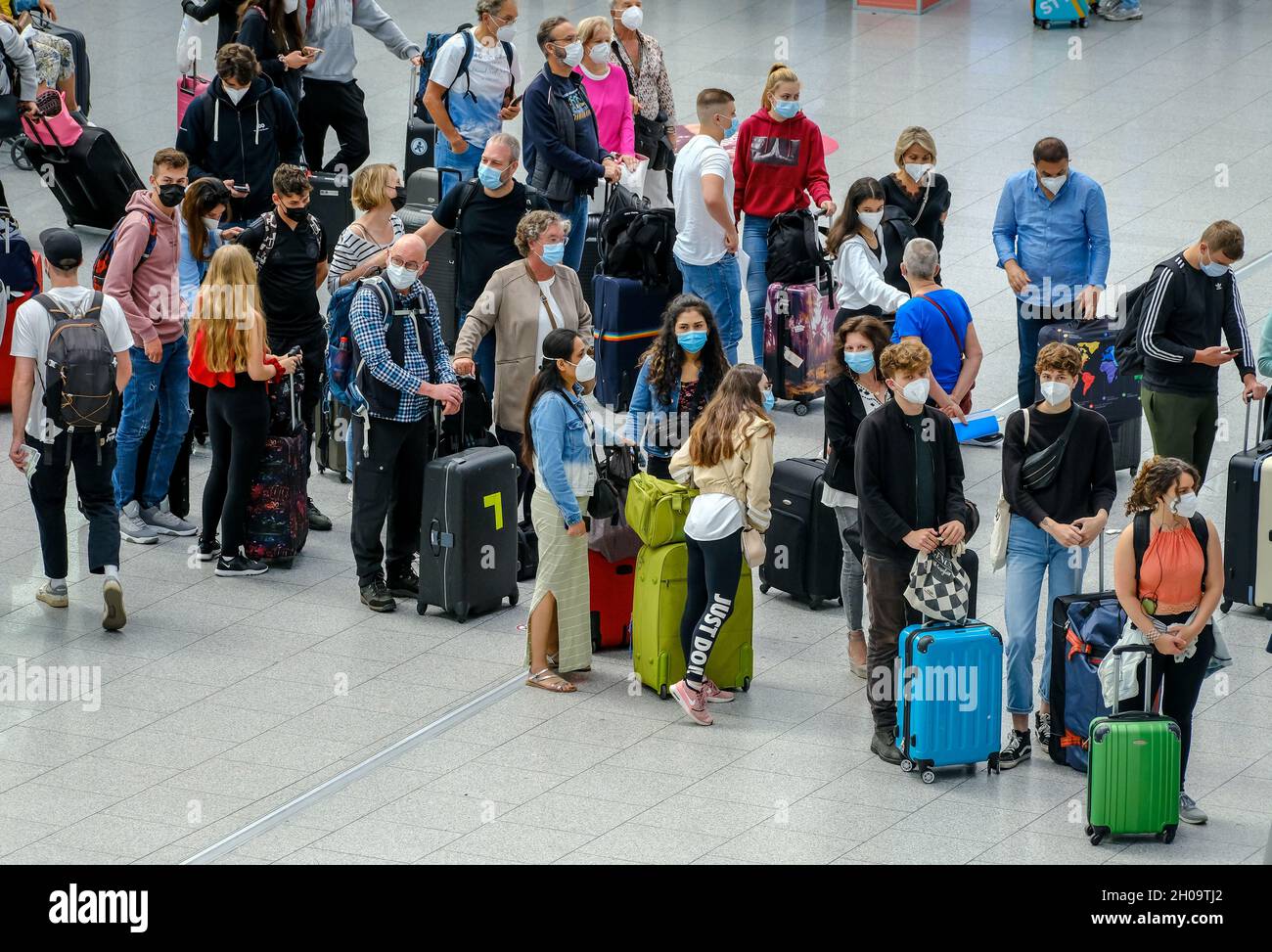 '02.07.2021, Deutschland, Nordrhein-Westfalen, Düsseldorf - Düsseldorf Airport, Urlaubsstart in NRW, Urlauber stehen mit Koffern in der Schlange Stockfoto