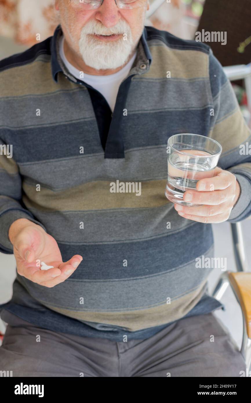 Kahler alter Mann mit Brille, der seine täglichen Medikamente nimmt. Selektiver Fokusmann Stockfoto