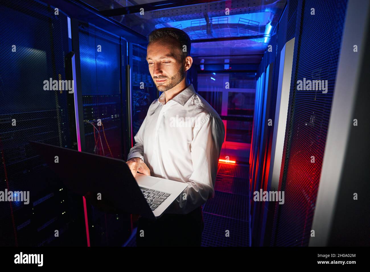 Systemtechniker, der die Diagnose von Server-Racks mit Laptop ausführt Stockfoto