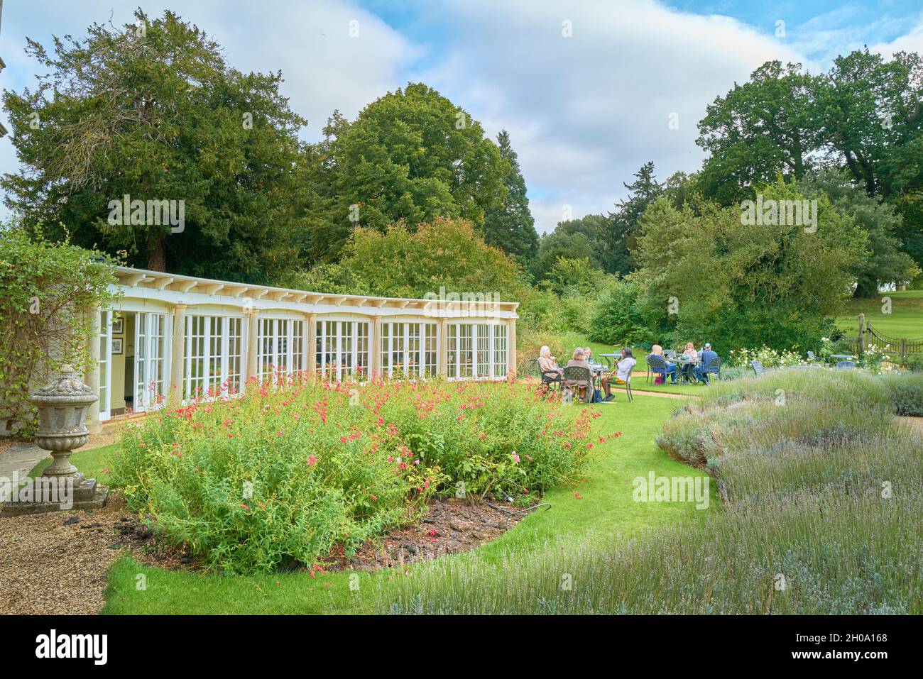 Besucher sitzen im Garten des Orangery-Restaurants im Burghley House, Stamford, England. Stockfoto