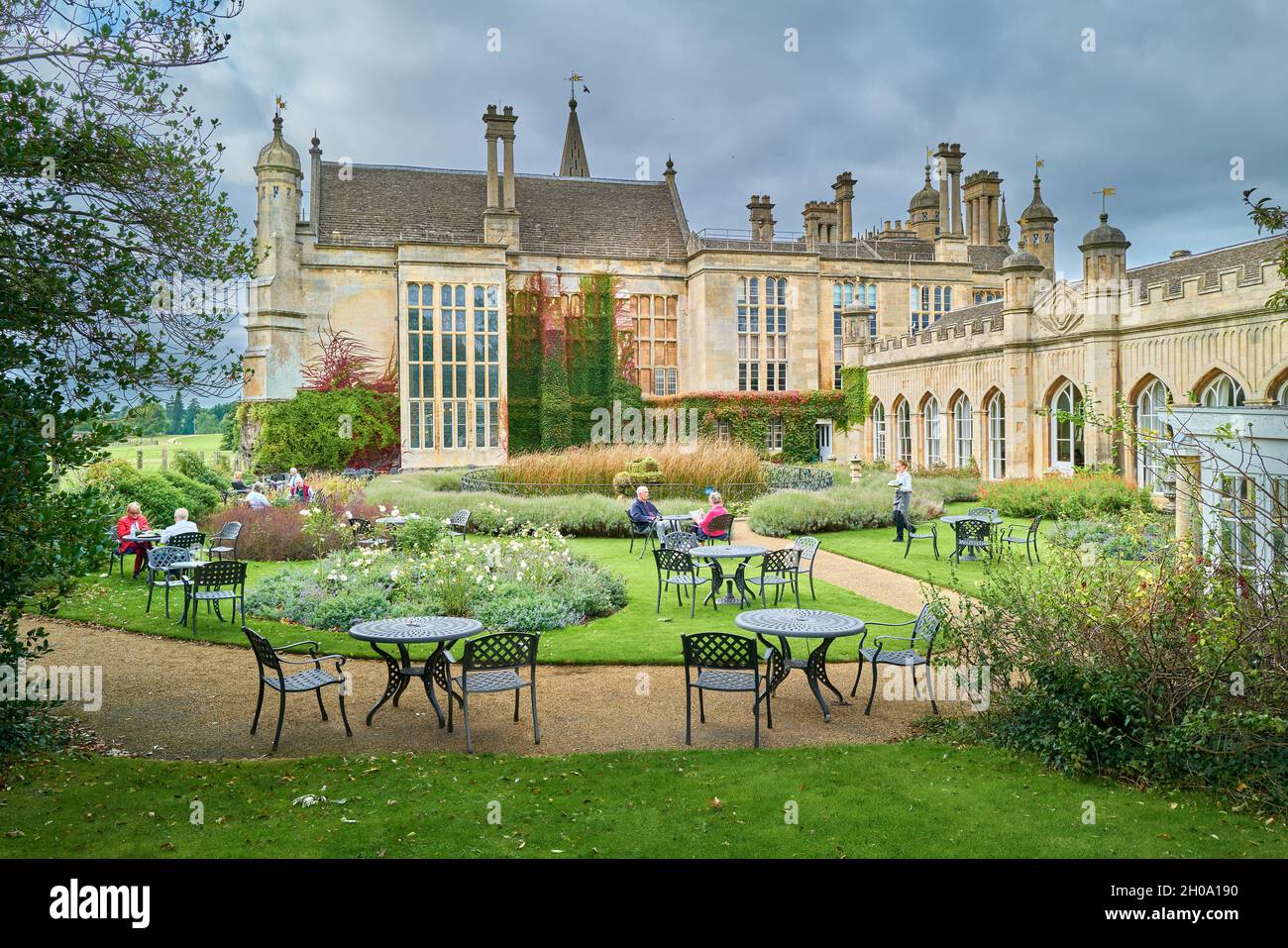 Besucher sitzen im Garten des Orangery-Restaurants im Burghley House, Stamford, England. Stockfoto