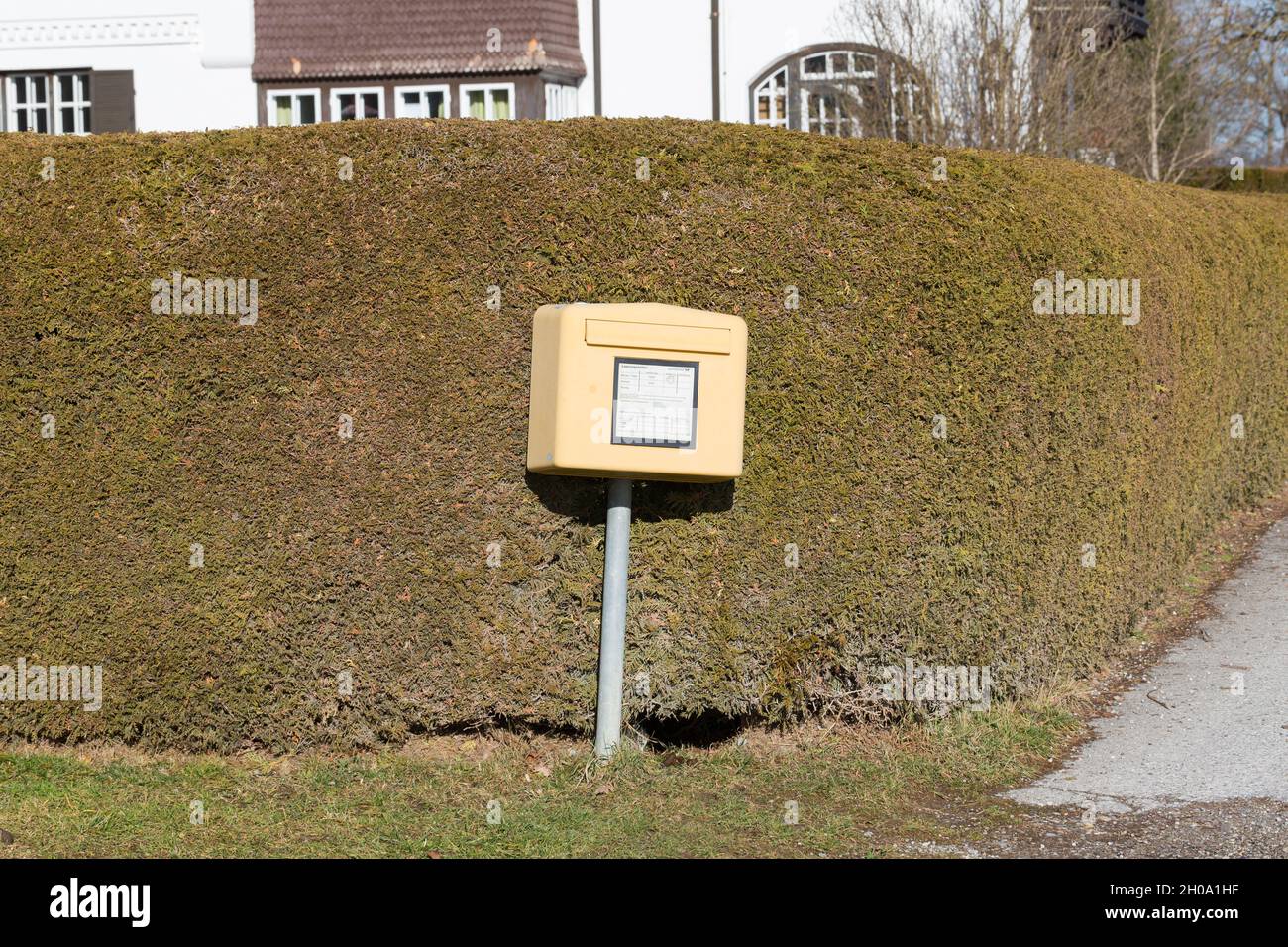St. Alban, Deutschland - 2. Feb 2021: Briefkasten vor einer Hecke. Symbol für Deutsche Post, Post, Offline-Post. Stockfoto